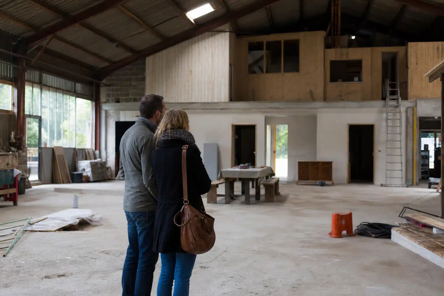 Couple regardant l'intérieur d'un bâtiment en rénovation